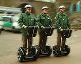 Red self-balancing two-wheeled board with a person standing on it.png